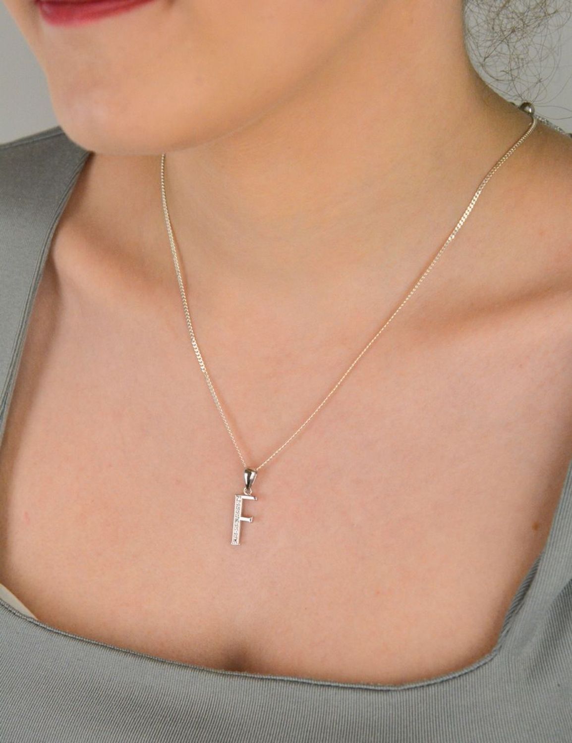 Zawieszka literka F z cyrkoniami próba 925, AP17-0213 F Zawieszka w kształcie literki „F” ozdobiona cyrkoniami to elegancka i subtelna biżuteria wykonana z wysokiej jakości srebra próby 925. 1.jpg